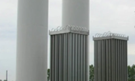Zbiornik magazynowy w postaci stalowego cylindra wykonany z materiału kompozytowego w przemysłowym otoczeniu. Koncepcja inżynierii i przemysłu z silosem stalowym i aluminiowym.