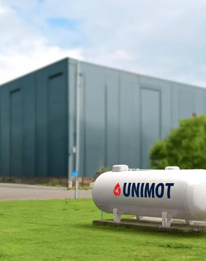 Zbiornik przemysłowy przechowujący gaz propan o oznaczeniu UNIMOT. Kształt cylindryczny z przyłączonymi rurami.